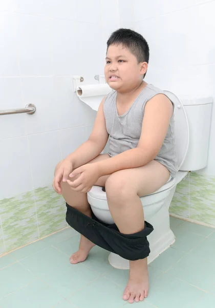 Fat boy suffer stomach and sit in toilet, diarrhea constipation and health concept — Stock Image Fat Boy Suffer Stomach Sit Toilet Diarrhea Constipation Health Concept Royalty Free Stock Images