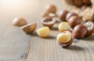 Eski ahşap zemin üzerine macadamia fıstığı kabuklu ve unshelled