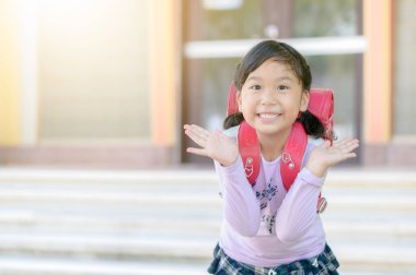 Okula, okul kavramı geri gülümseyen sırt çantası ile mutlu küçük kız