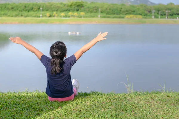 健康公園の湖の近くの腕を上げる少女 健康的なライフ スタイルと自由の概念 — ストック写真