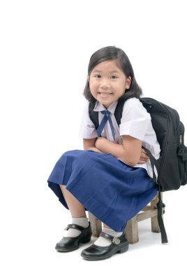 Asyalı kız öğrenci okul çantası ile ahşap sandalye okul kavramı başa beyaz arka plan üzerinde izole oturmak