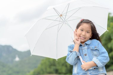 şirin Asyalı kız gülümseme ve doğa arka planda, sağlıklı kavramı holding Beyaz şemsiye