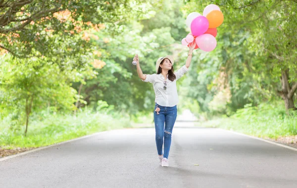 Young hipster girl holding balloon walk on the road, Freedom and recreation concept