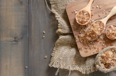 Kahverengi taş şeker tahta kaşık ve eski ahşap arka plan, üstten görünüm ve kopya alanı