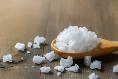 Ahşap masa arka plan, yumuşak odak üstünde tahta kaşık kapalı deniz tuzu