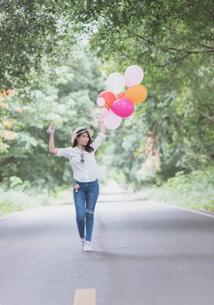 Young hipster girl holding balloon walk on the road, Freedom and recreation concept