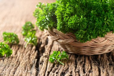 Taze maydanoz yaprak bambu sepet ve ahşap arka plan, ot ve madde gıda kavramı