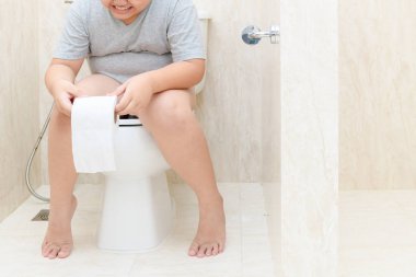 Tuvalette otururken ve doku rulo, ishal kabızlık tutan çocuk. Sağlık ve temizlik kavramı