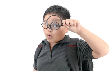 Holding ve büyüteç büyük bir gözün seyir mutlu Asyalı okullu çocuk izole beyaz arka plan üzerinde eğitim kavramı