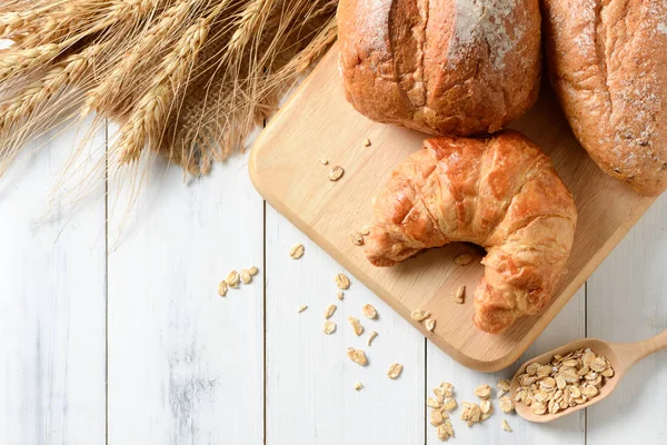 Huisgemaakte croissants en brood op oude hout — Stockfoto