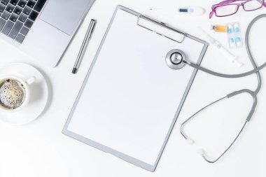 Kalem ile Panosu'ndaki üstten görünüm doktor Danışma tablo stetoskop, kahve ve boş kağıt. Üstten Görünüm kopya alanı, düz ile yatıyordu.