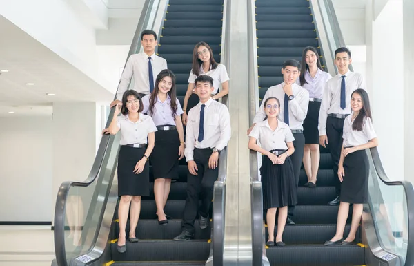 Розумні молоді студенти, що стоять разом на ескалаторі — стокове фото