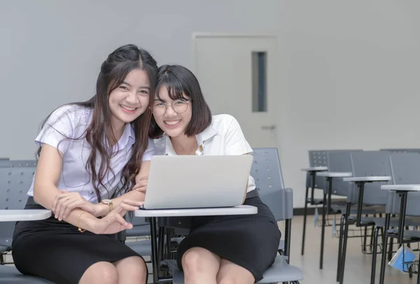 Söta studenter ler och arbetar med laptop — Stockfoto