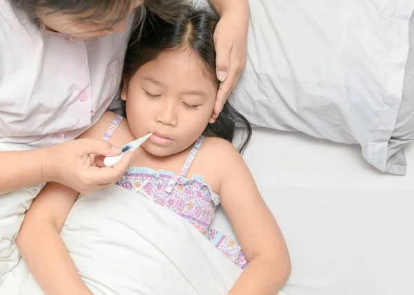 Mamma mäter temperatur av sjuk unge. — Stockfoto