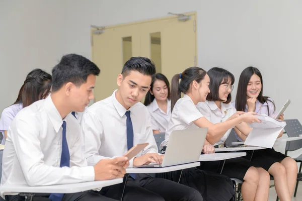 Adolescentes Estudantes de uniforme trabalhando com laptop em sala de aula — Fotografia de Stock