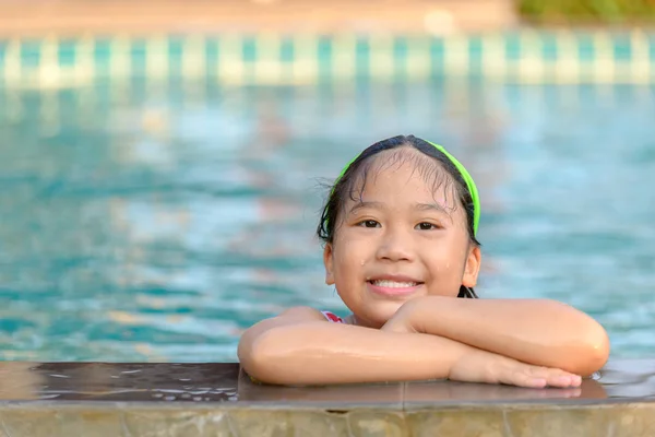 Söpö tyttö uimapuvussa ui altaassa — kuvapankkivalokuva