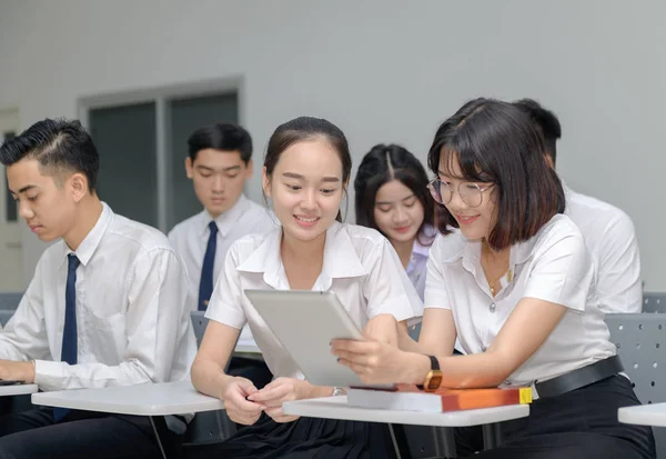 Students in uniform working with tablet — Stock Photo, Image