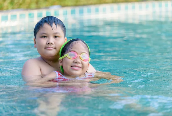 Feliz hermano y hermana jugando en la piscina , — Foto de Stock