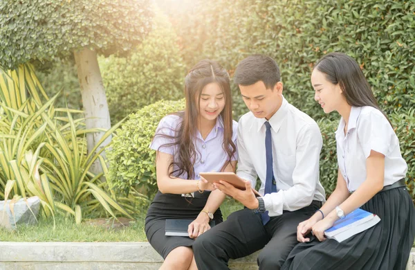 Estudantes asiáticos usando tablet para fazer lição de casa — Fotografia de Stock