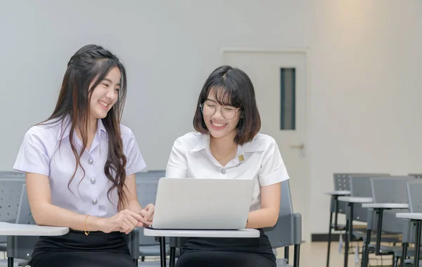 Söta studenter i uniform arbeta med laptop — Stockfoto