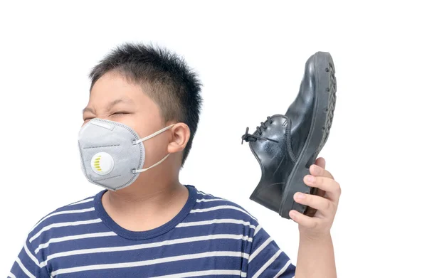 Нечистий хлопчик тримає пару смердючих шкіряних черевиків — стокове фото