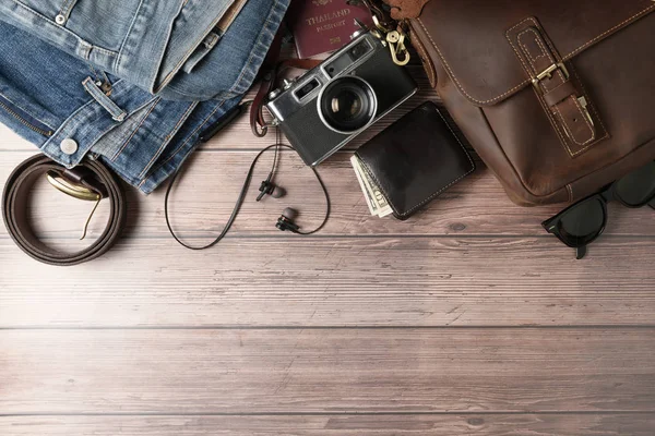 Saco de couro vintage e jeans velhos em madeira — Fotografia de Stock