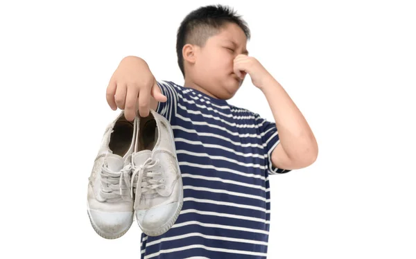 Αηδιασμένος χοντρός που κρατάει ένα ζευγάρι παπούτσια που βρωμάνε — Φωτογραφία Αρχείου