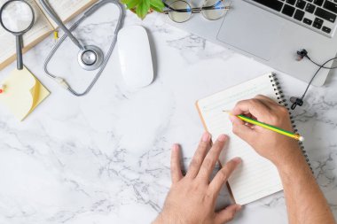 Doktor mermer masaya boş not defteri yazıyor 