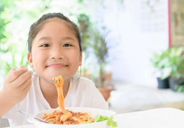 女の子はポークソースでスパゲッティを食べて楽しむ — ストック写真