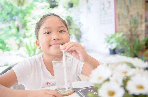 Cate Asian girl drinking glass of water with ice