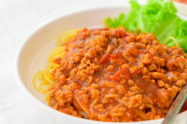 Espaguetis con salsa de cerdo sobre mesa blanca , — Foto de Stock