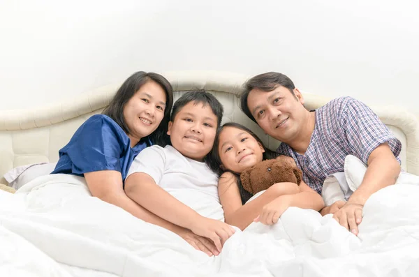 Щаслива Азіатська сім'я лежачи і посміхатися на ліжку — стокове фото