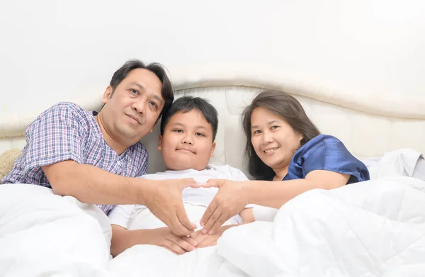Щаслива сім'я і син лежать на ліжку , — стокове фото