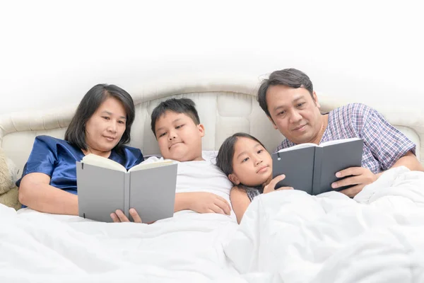 Щаслива сім'я читає історію на ліжку — стокове фото