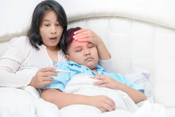 Madre comprobando la temperatura de su hijo enfermo —  Fotos de Stock