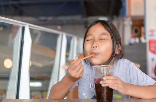 Šťastná dívka pije colu smoothie z plastového poháru — Stock fotografie