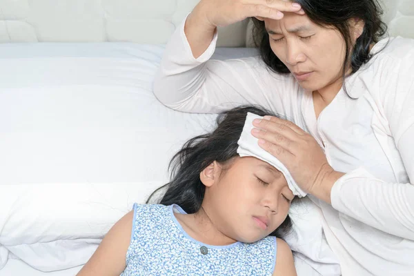 Mamá sufriendo de migraña porque su hija está enferma —  Fotos de Stock