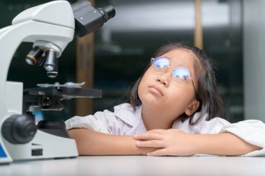 Küçük çocuk okul laboratuarında düşünüyor ve öğreniyor. 