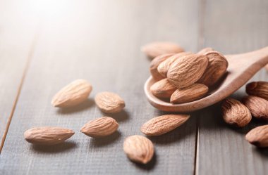 Badem fıstıkları ahşap masadaki tahta kaşıkta soyulmuş. Badem çok popüler bir fındık ve yüksek proteindir. sağlıklı yiyecekler.