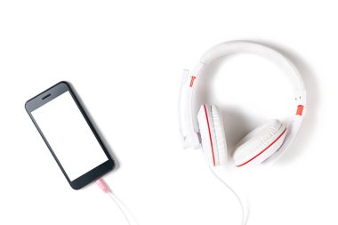 Beyaz arka planda beyaz ekranlı beyaz kulaklık ve cep telefonu