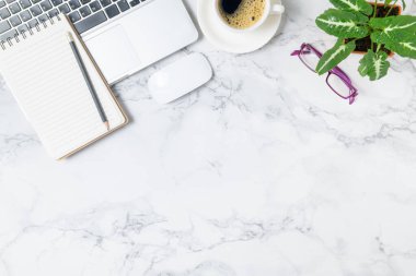 Boş defterde dizüstü bilgisayarı ve mermer masa arkasında sade kahvesi olan kalem, üst görünüm ve fotokopi alanı, iş ve işyeri kavramı