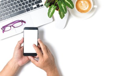 Beyaz ekran akıllı telefona dokunan beyaz arka planda izole edilmiş bilgisayar ve kahve, üst görünüm ve iş konsepti