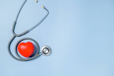 Kırmızı kalp ve steteskop mavi arkaplanda izole edilmiş, üst görünüm ve kopyalama alanı, Doktor Günü konsepti