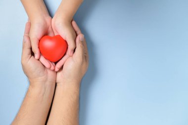 Yetişkin ve çocuk elleri kırmızı kalbi tutarken beyaz arka planda izole edilmiş sağlık, aşk ve aile sigortası konsepti, dünya kalp günü