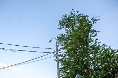 Mavi gökyüzüne karşı kablolu fener.