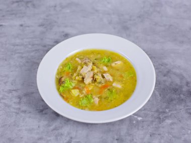 Beyaz tabakta tavuk çorbası.