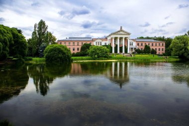 Şehir parkındaki eski bina ve gölet manzarası