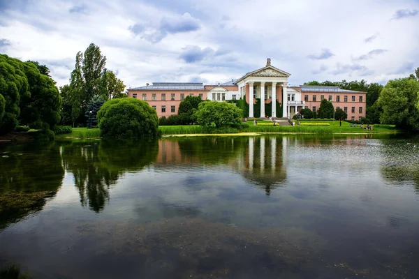 Şehir parkındaki eski bina ve gölet manzarası