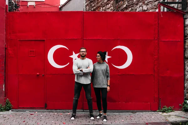 Selfie guy and girl. Couple in Turkey. Couple on the background of the flag. Guy and girl traveling. Man and woman. Turkish flag. Couple on a background of graffiti. Graffiti on the wall