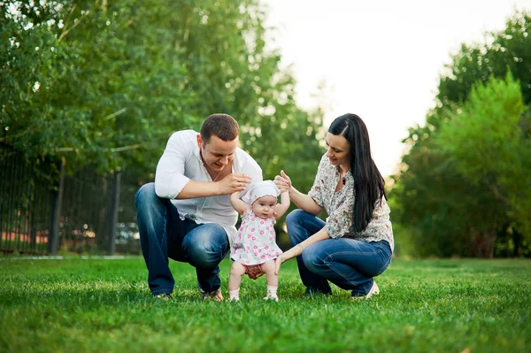 Mutlu aile anne, Baba, çocuk. Mutlu genç aile birlikte dışında yeşil doğada vakit. Mutlu bir aile birlikte yeşil çimenlerin üzerinde dinlenme. Mutlu aile açık havada eğleniyor